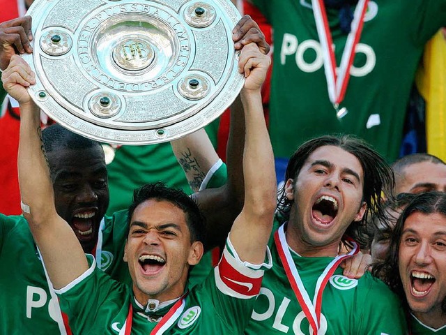 Da ist das Ding: Die Wolfsburger Spieler feiern den Gewinn der Meisterschaft.  | Foto: ddp