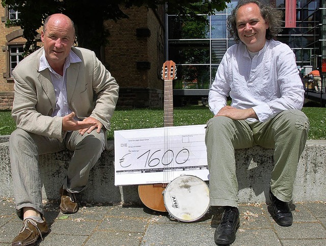 Armin Krger (links) hat einen Scheck ...hts) mit seinen Trommlern  gesammelt.   | Foto: rab
