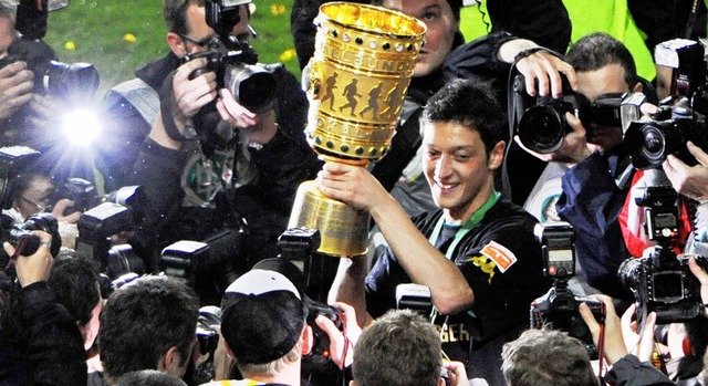 Spieler des Abends: Mesut zil prsentiert den Pokal.  | Foto: dpa (2)/ddp