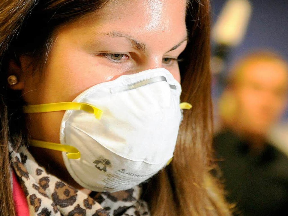 Frau mit Mundschutz: Experten rechnen ...em Impfstoff gegen die Schweinegrippe.  | Foto: dpa