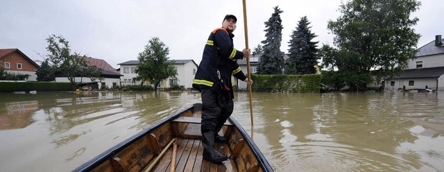 Ein Helfer schippert mit einem Kahn du...raen von St. Leonhard in sterreich.   | Foto: dpa