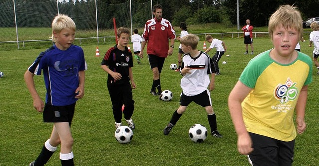 DFB-Trainer Sascha Burkard (Mitte) gab den Kindern Tipps frs Fuballspiel.   | Foto: Gut