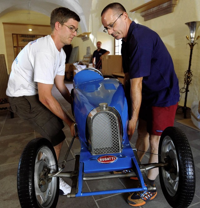 Vorsichtig anheben und nicht anecken: ...Bugatti von 1927 wird zurecht gerckt   | Foto: AFP