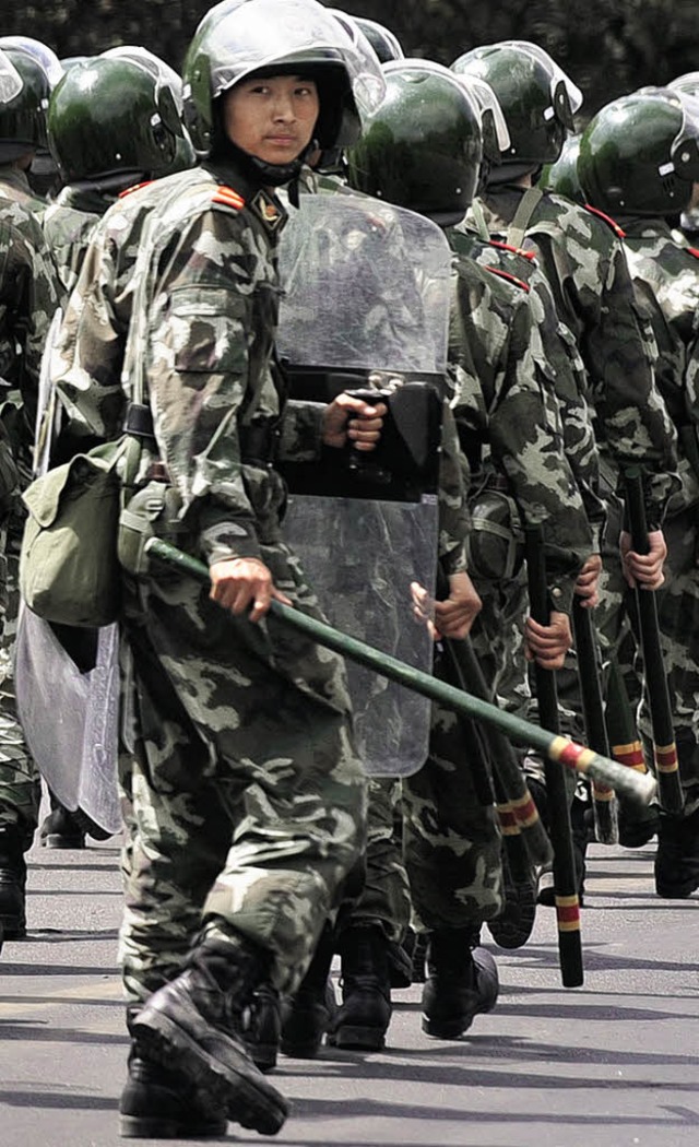 Chinesische Polizisten  laufen am Mont...chinesischen Stadt Urumqi Patrouille.   | Foto: AFP