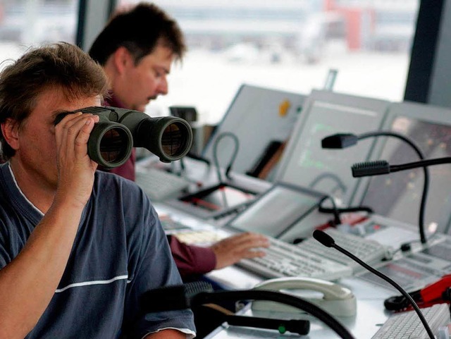 Ein Fluglotse kontrolliert das Gescheh...debahn ausnahmsweise mit dem Fernglas.  | Foto: ddp