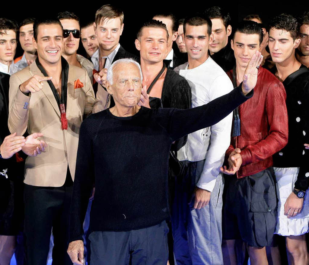 Der Modedesigner Giorgio Armani  nach einer Modenschau in Paris zwischen seinen Models.