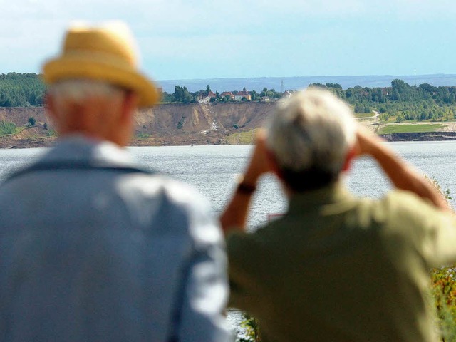 Schaulustige stehen  auf einem Aussichtspunkt   am Concordiasee.  | Foto: dpa