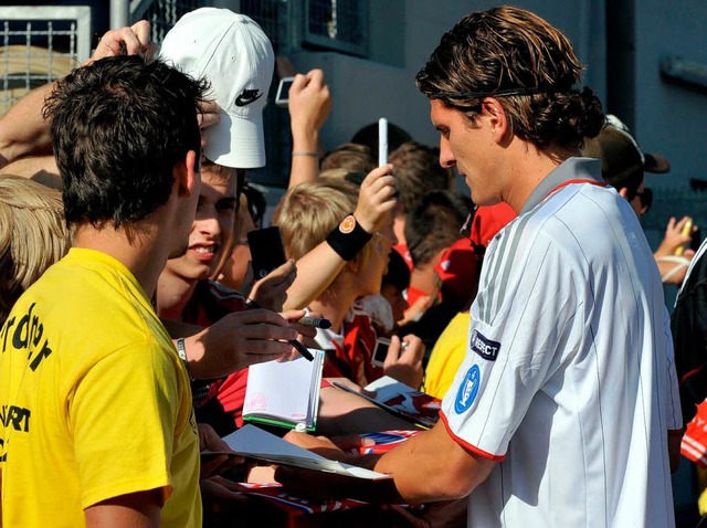 Der Neu-Mnchner Mario Gomez schreibt fleiig Autogramme.  | Foto: dpa