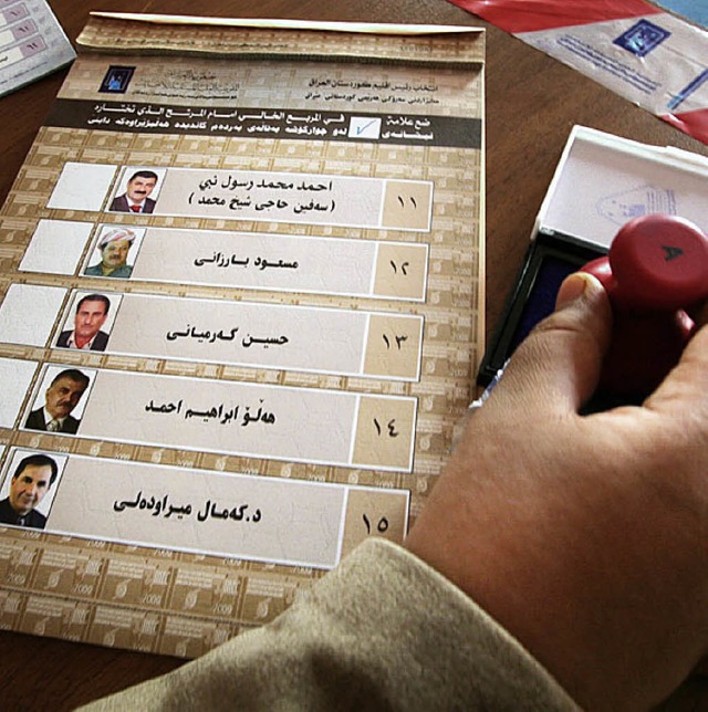 Ein Wahlhelfer gibt in Bagdad bereits Wahlzettel aus.   | Foto: AFP