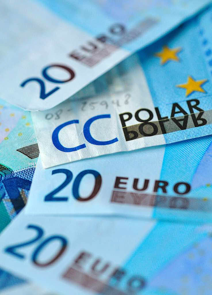 Ein geflschter 20-Euro-Geldschein mit der Aufschrift "CC Polar" ist in Frankfurt am Main zwischen mehreren echten Banknoten zu sehen.