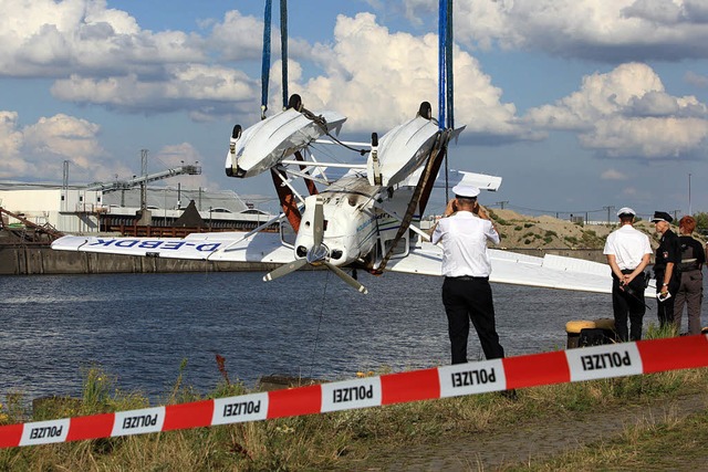Die Feuerwehr birgt das Flugzeug-Wrack aus dem Hafenbecken.   | Foto: DPA