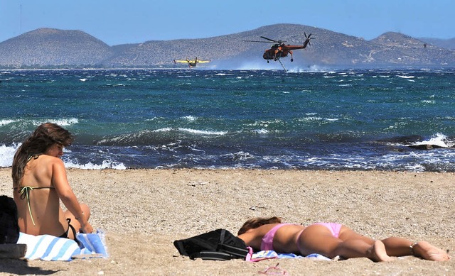 Touristinnen brunen sich am Strand vo...uge regelmig Wasser aufnehmen.        | Foto: AFP