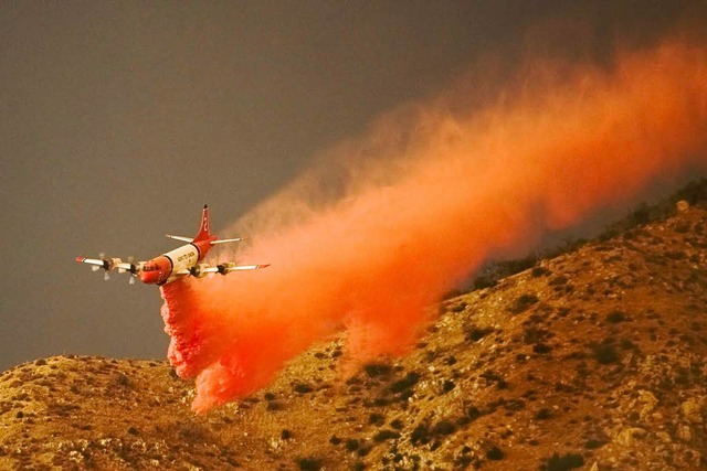 Vor den Flammen bringen Flugzeuge brandhemmende Mittel aus.   | Foto: dpa