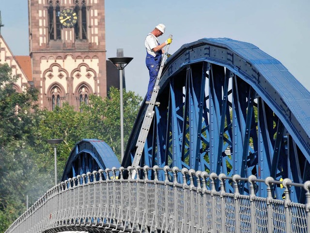 Ein Arbeiter legt letzte Hand an die nunmehr sanierte Wiwili-Brcke in Freiburg.  | Foto: Ingo Schneider