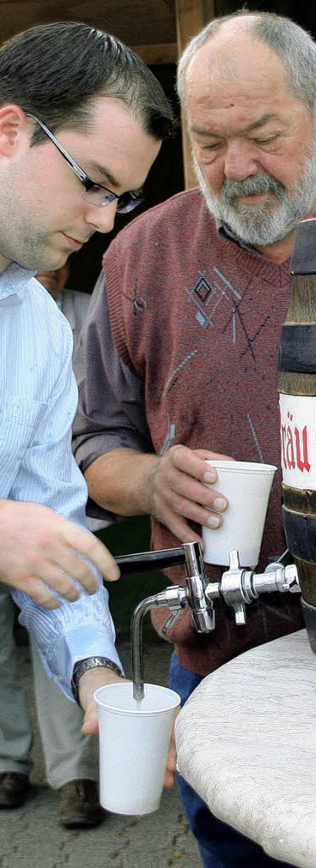 Brgermeister Ulrich Krieger (links) z...g das erste Bier fr die Festbesucher.  | Foto: Charlotte Frse