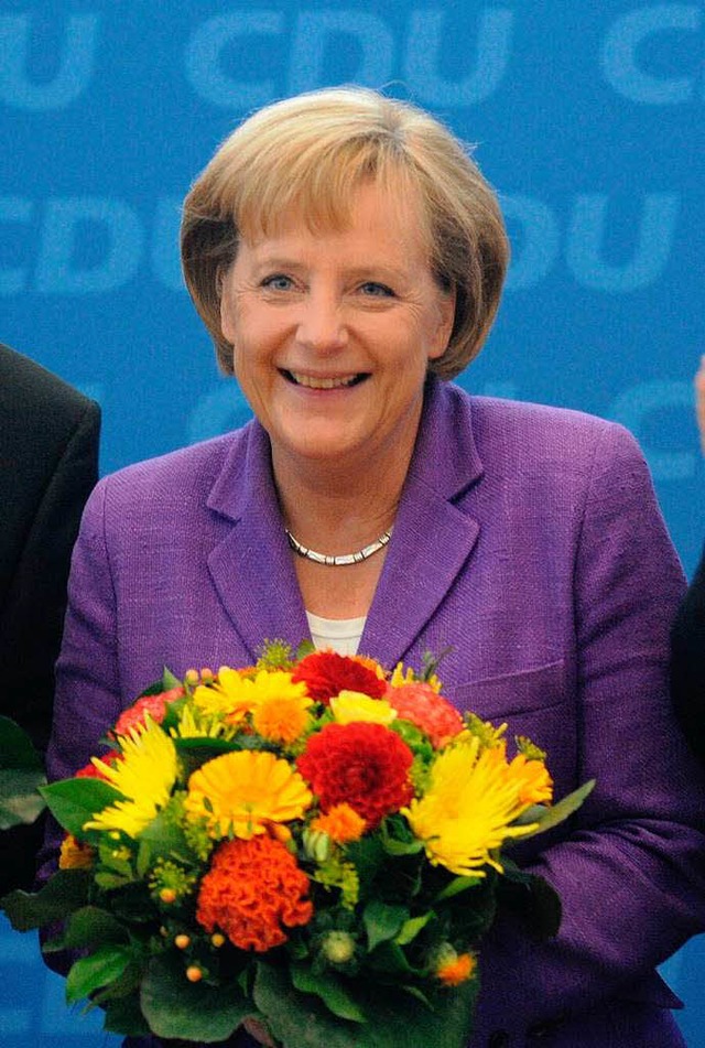 Angela Merkel mit Blumen von der CDU. ...n Staatschefs gratulierten mit Worten.  | Foto: dpa