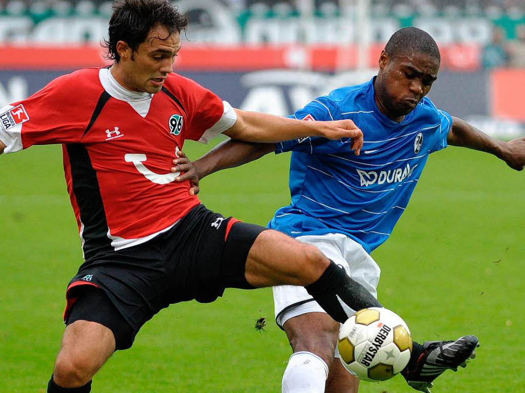 Der Hannoveraner Sofian Chahed (l) und der Freiburger Mohamadou Idrissou kmpfen um den Ball.