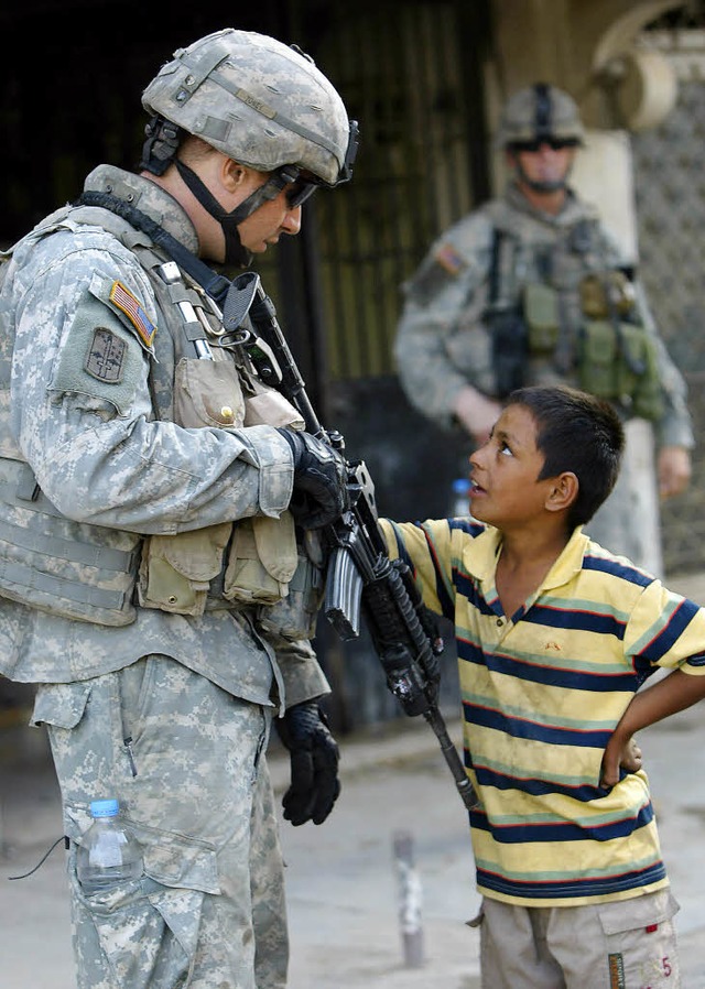 Ein US-Soldat unterhlt sich mit einem irakischen Jungen.   | Foto: afp