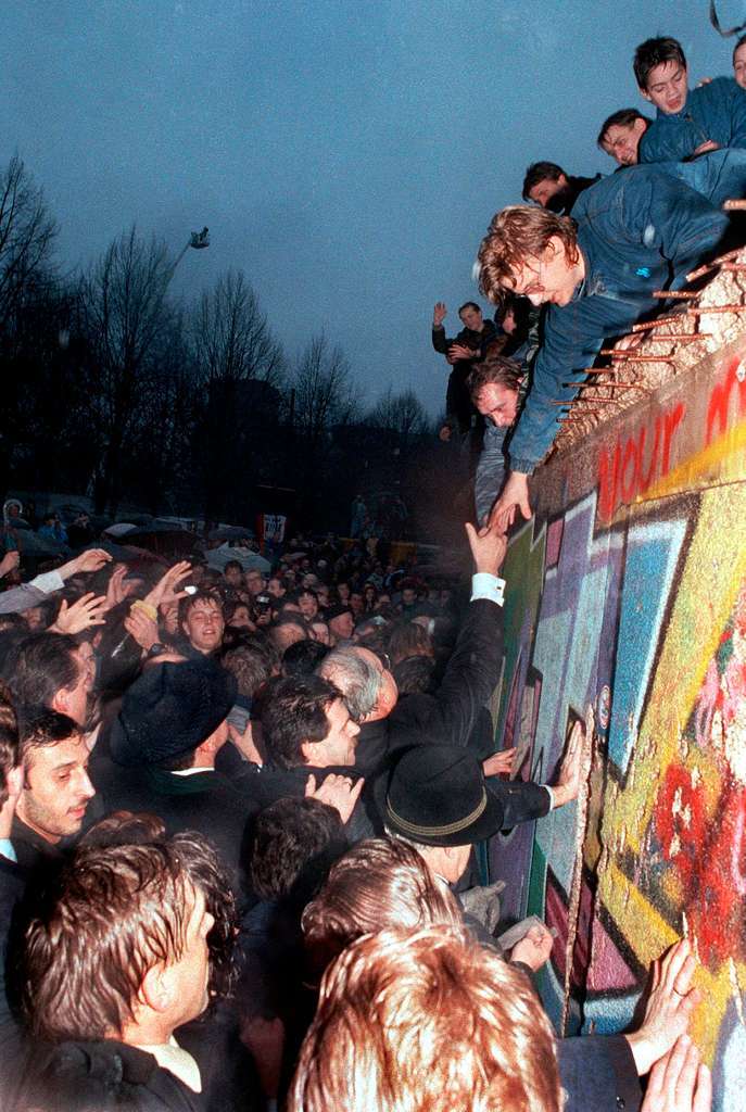 Bundeskanzler Helmut Kohl (M.) schttelt am 22.12.1989 Berlinern, die die Mauer am Brandenburger Tor erklommen haben, die Hnde.