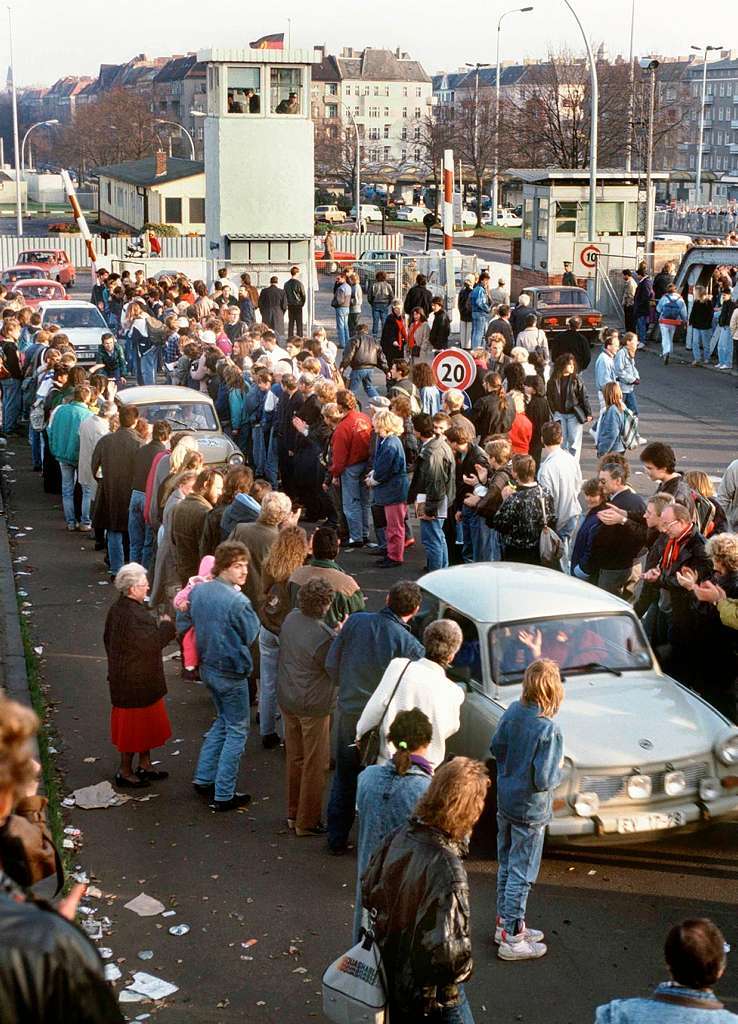 Jubelnde Berliner freuen sich ber die Fahrt einer Trabi-Kolonne ber den Grenzbergang Bornholmer Strae nach West-Berlin, 10.11.1989.