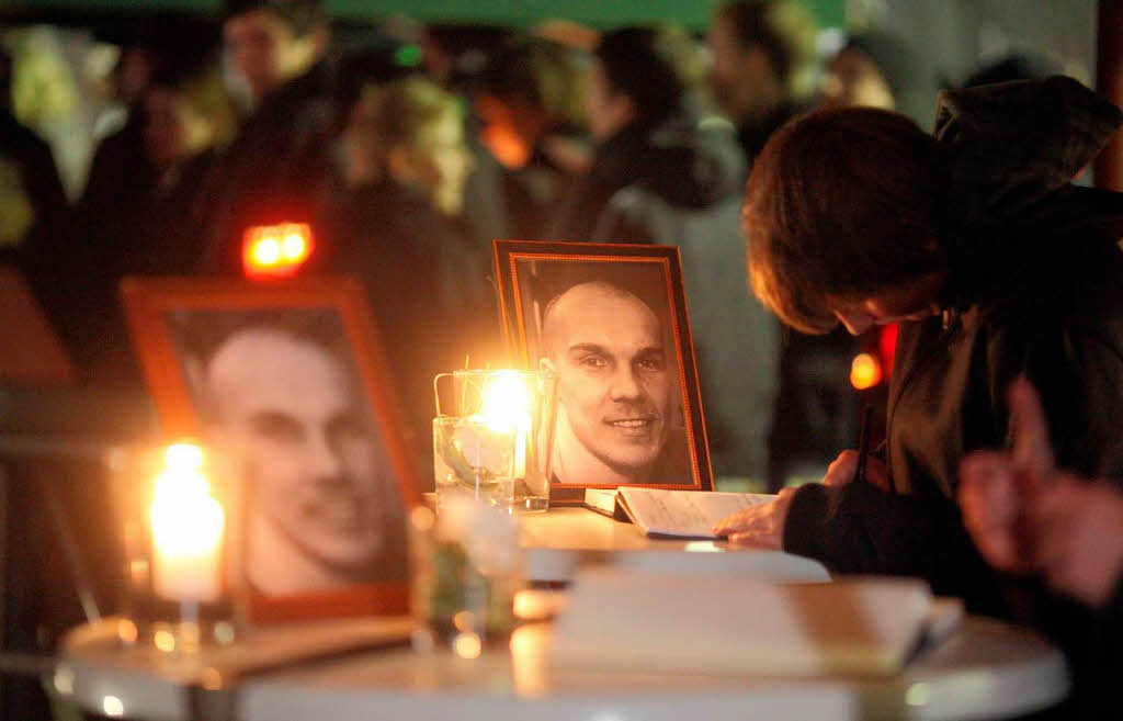 Fans von Hannover 96 tragen sich  vor der AWD-Arena in Hannover in ein Kondolenzbuch ein.