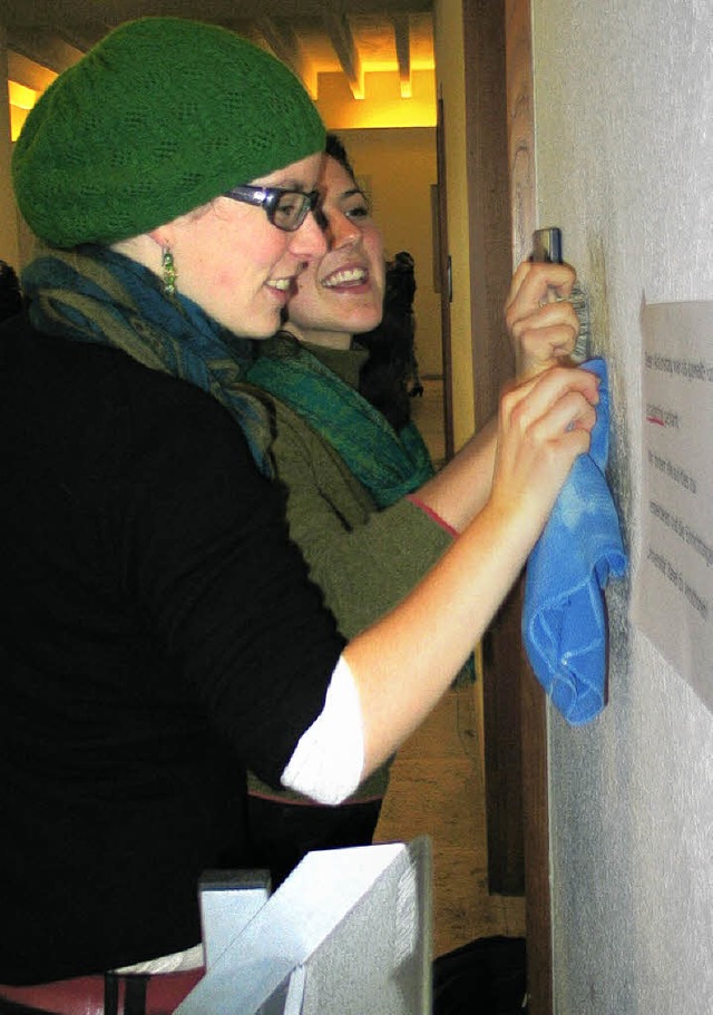 Zwei Studentinnen entfernen  Graffiti in der Uni Basel.   | Foto: Bianca Fritz
