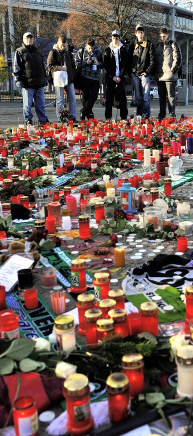 Den Trauernden, wie hier vor dem Stadi... Hannover,  stellen sich viele Fragen.  | Foto: dpa