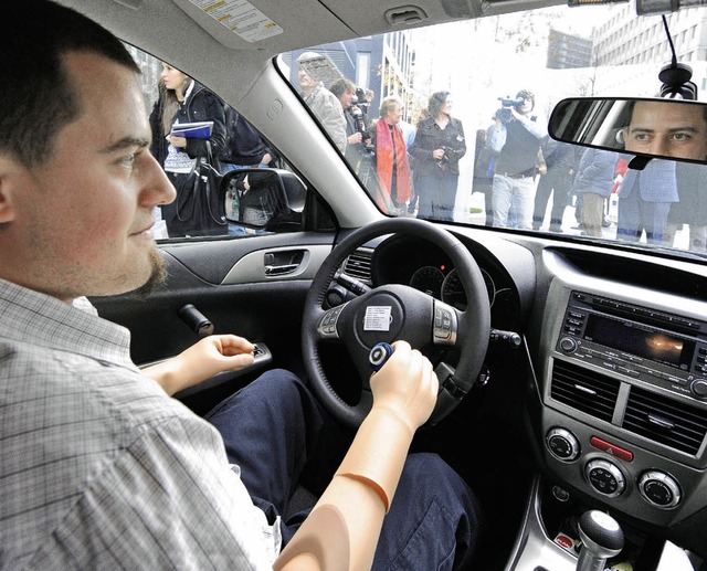 Christian Kandlbauer  sitzt am Steuer seines eigens fr ihn umgebauten Autos.   | Foto: dpa