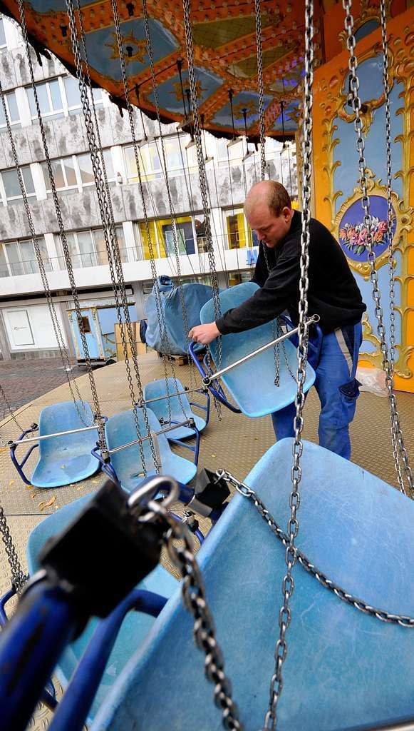 Timo Kossmann richtet die Sitze am Kettenkarussel auf dem Kartoffelmarkt.