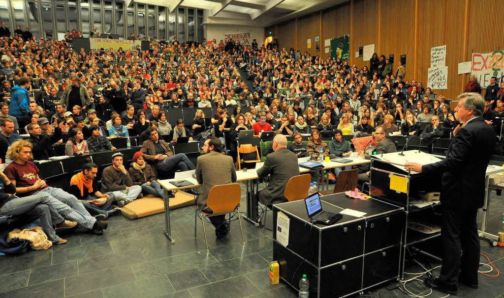 Engagierte Diskussion auf beiden Seiten: Freiburgs Uni-Rektor Hans-Jochen Schiewer und die Studenten im proppenvollen Audimax.