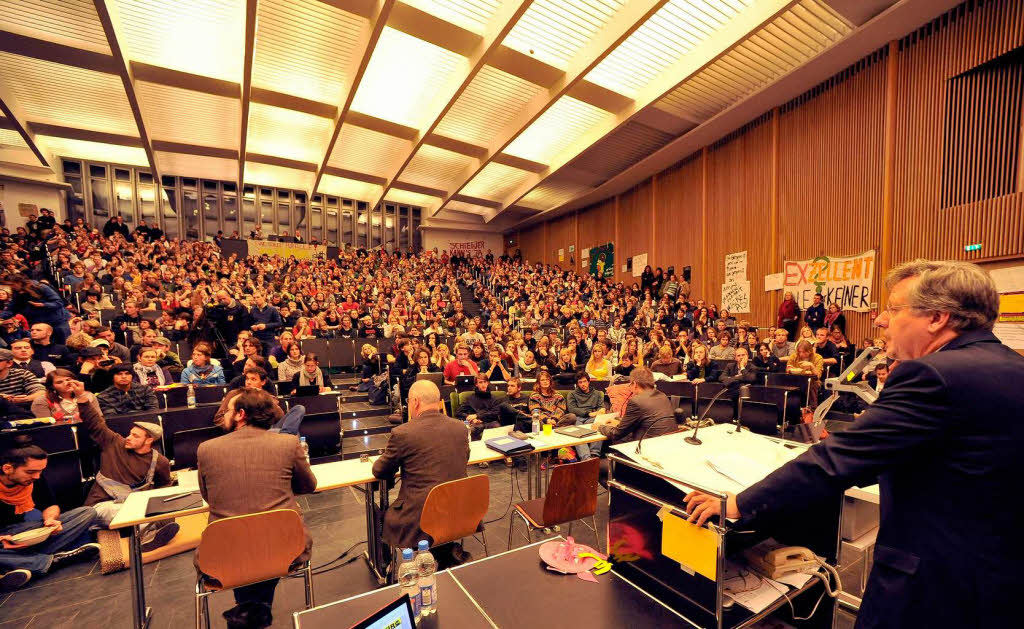 Engagierte Diskussion auf beiden Seiten: Freiburgs Uni-Rektor Hans-Jochen Schiewer und die Studenten im proppenvollen Audimax.