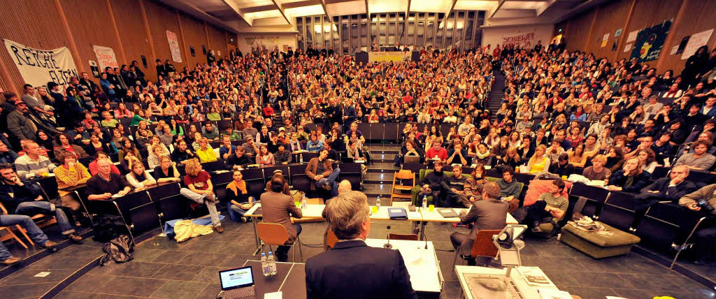 Engagierte Diskussion auf beiden Seiten: Freiburgs Uni-Rektor Hans-Jochen Schiewer und die Studenten im proppenvollen Audimax.