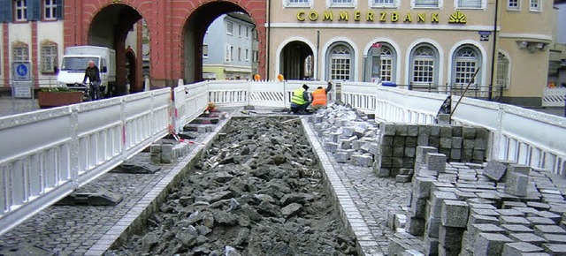 Kaum verlegt, schon defekt: Das neue Pflaster vor dem Tor wird repariert.  | Foto: Gerhard Walser
