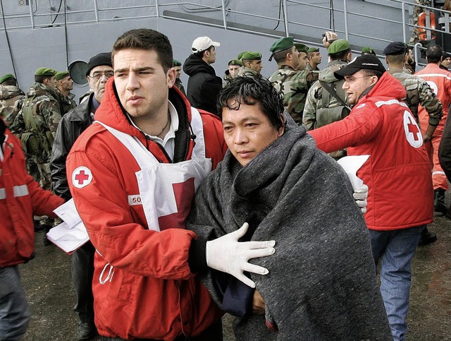 Helfer haben einen der Schiffbrchigen...nn wurde in ein Krankenhaus gebracht.   | Foto: AFP