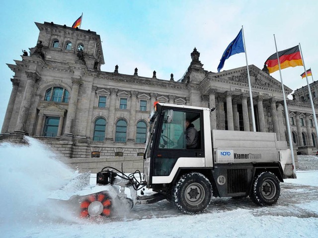 Ein Schneepflug rumt vor dem Reichstag in Berlin Schnee.  | Foto: dpa