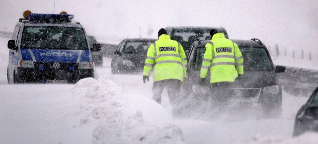 Polizisten betreuen am Sonntag auf der...es im Schnee festsitzende Autofahrer.   | Foto: ddp