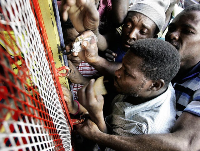 Diese Mnner drngen sich vor einer Au...und Anarchie auf Haiti zu verhindern.   | Foto: dpa