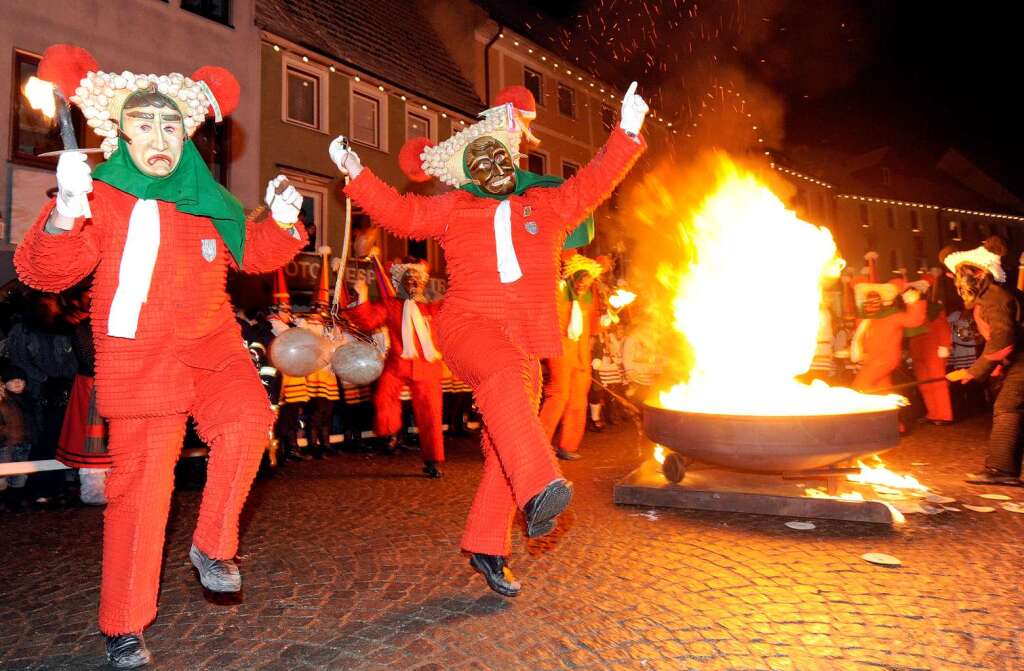 Elzacher Schuttig tanzen am Neckar um ein Feuer.