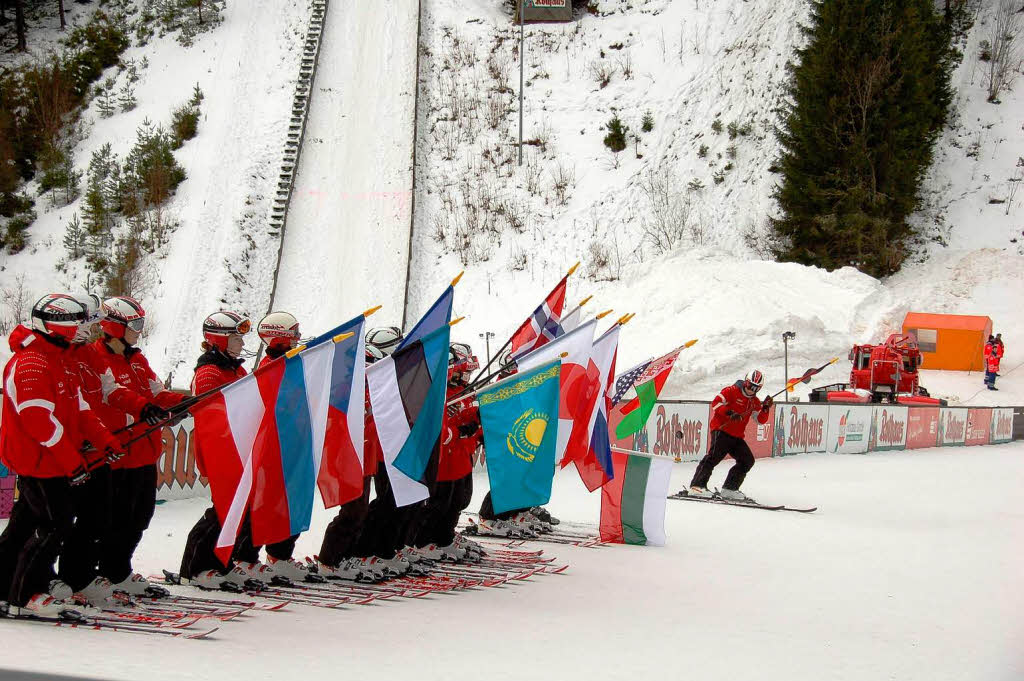 Die Nachwuchsskifahrer des Skiclubs Neustadt fahren mit den Fahnen der beteiligten Nationen den Sprunghgel hinunter.