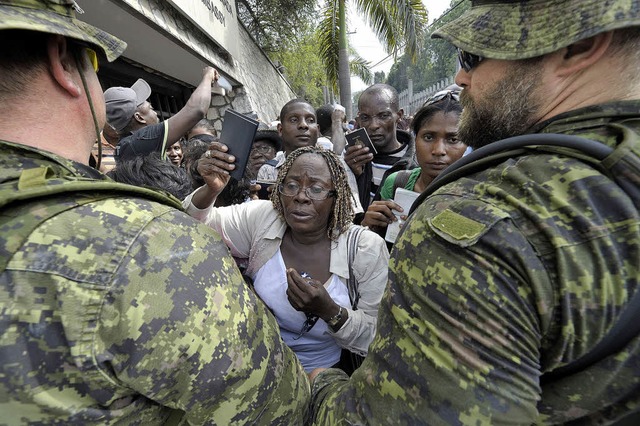 Verzweifelt versuchen Menschen, in die...fr die Ausreise in ein sicheres Land.  | Foto: afp