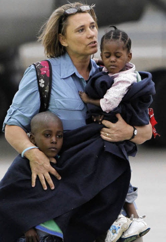 Eine Holländerin holt haitianische Adoptivkinder ab. | Foto: DPA Eine Holländerin holt haitianische Adoptivkinder ab. | Foto: DPA