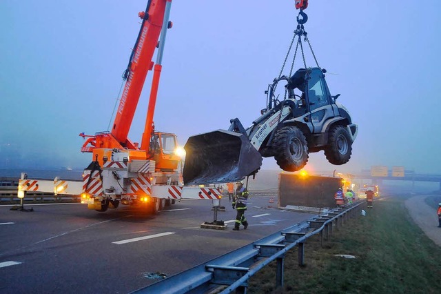 Ein Kranwagen der Freiburger Feuerwehr nimmt den Radlader an den Haken.  | Foto: Thomas Kunz