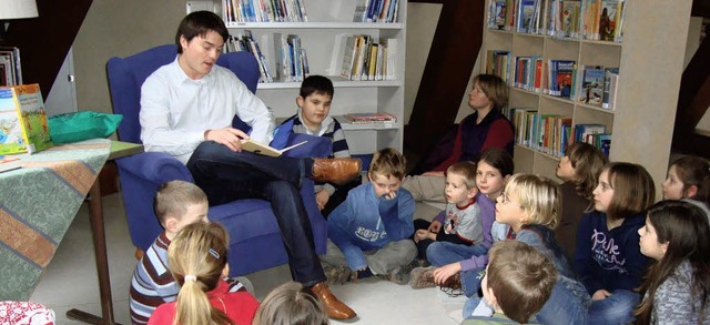 Brgermeister Matthias Gutbrod liest vor und die Kinder hren gespannt zu.   | Foto: Schule