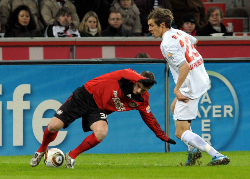 Der Leverkusener Toni Kroos (l) und der Freiburger Julian Schuster versuchen den Ball zu spielen.