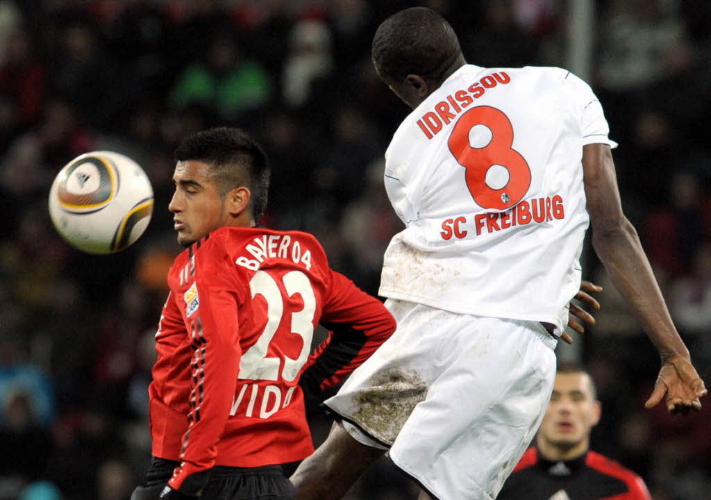 Der Leverkusener Arturo Vidal (l) und der Freiburger Mohamadou Idrissou versuchen den Ball zu spielen.