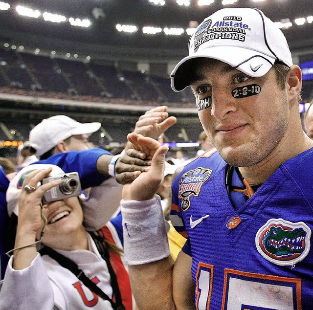 Footballer Tim Tebow (22) spielt zwar ...t auch Bibelverweise unter den Augen.   | Foto: AFP