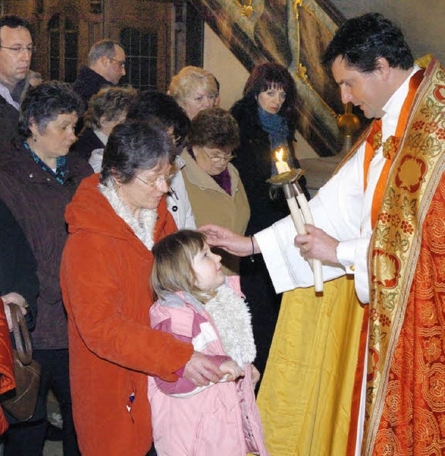 Pfarrer Thorsten Becker beim Erteilen des Blasius-Segens.   | Foto: Schweizer