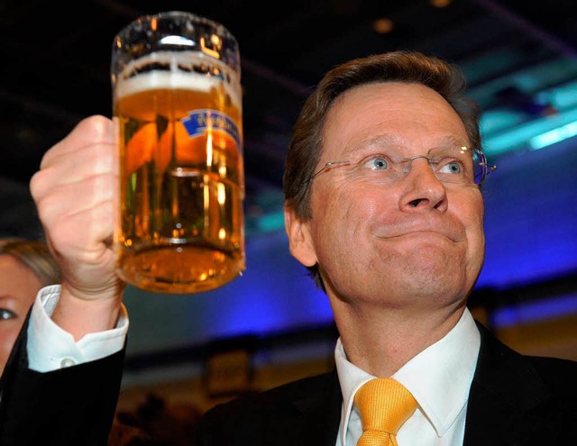 Guido Westerwelle hlt sich beim Politischen Aschermittwoch an einem Bier fest.  | Foto: dpa