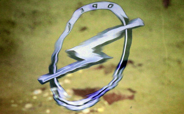 Das Opel-Logo spiegelt sich verschwommen im Wasser.   | Foto: dpa
