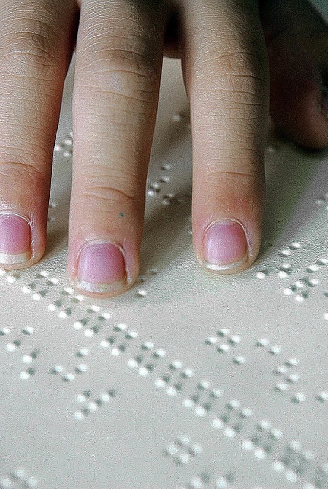Ein blinder Schler liest in einem Buch mit Braille-Schrift.  | Foto: dpa